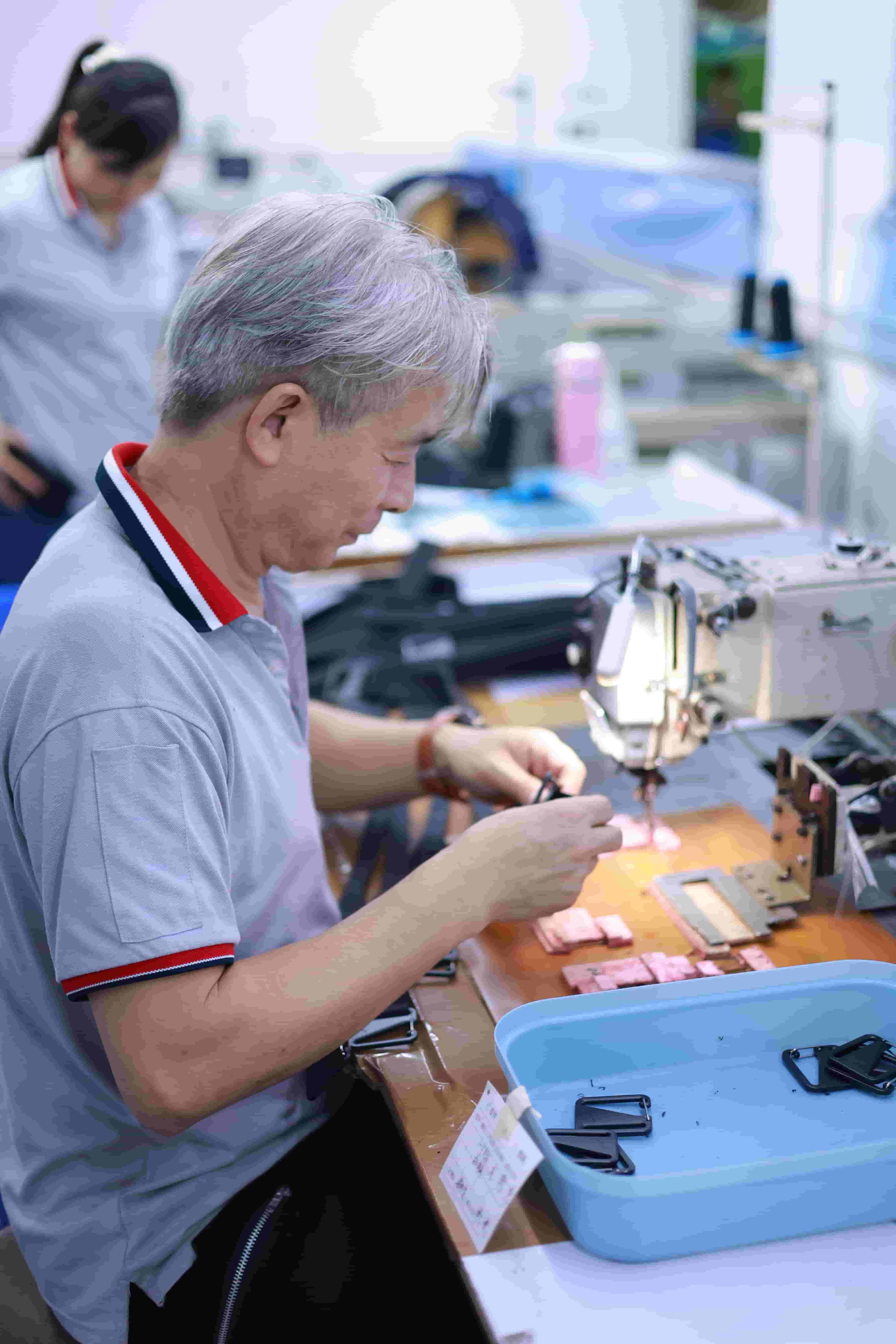 Pneumatic component press station pre-attaching Hypalon anchor patches onto waterproof backpack panels